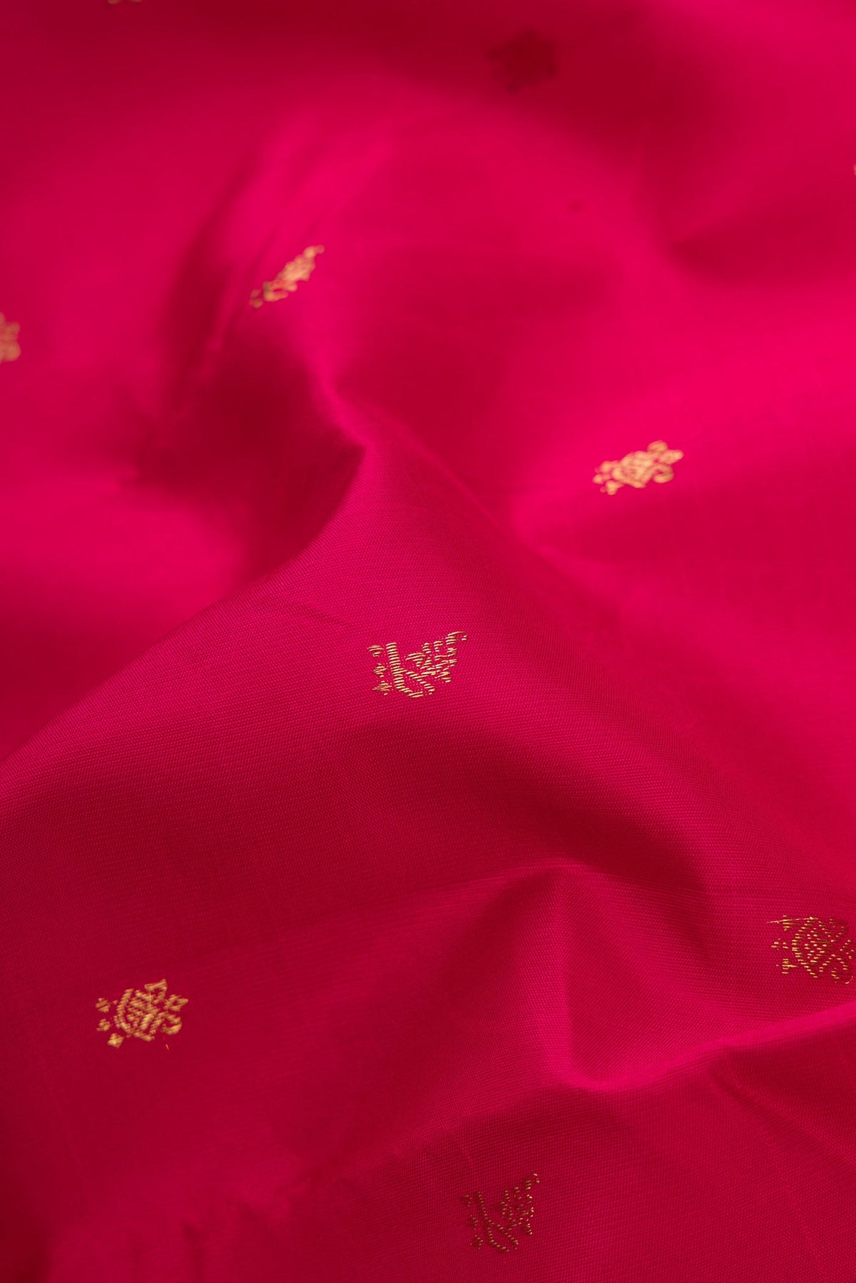 Close up of Maroon Dual Tone Kanchipuram Silk Saree with Zari Butta on the body and Temple Border.  displaying folds