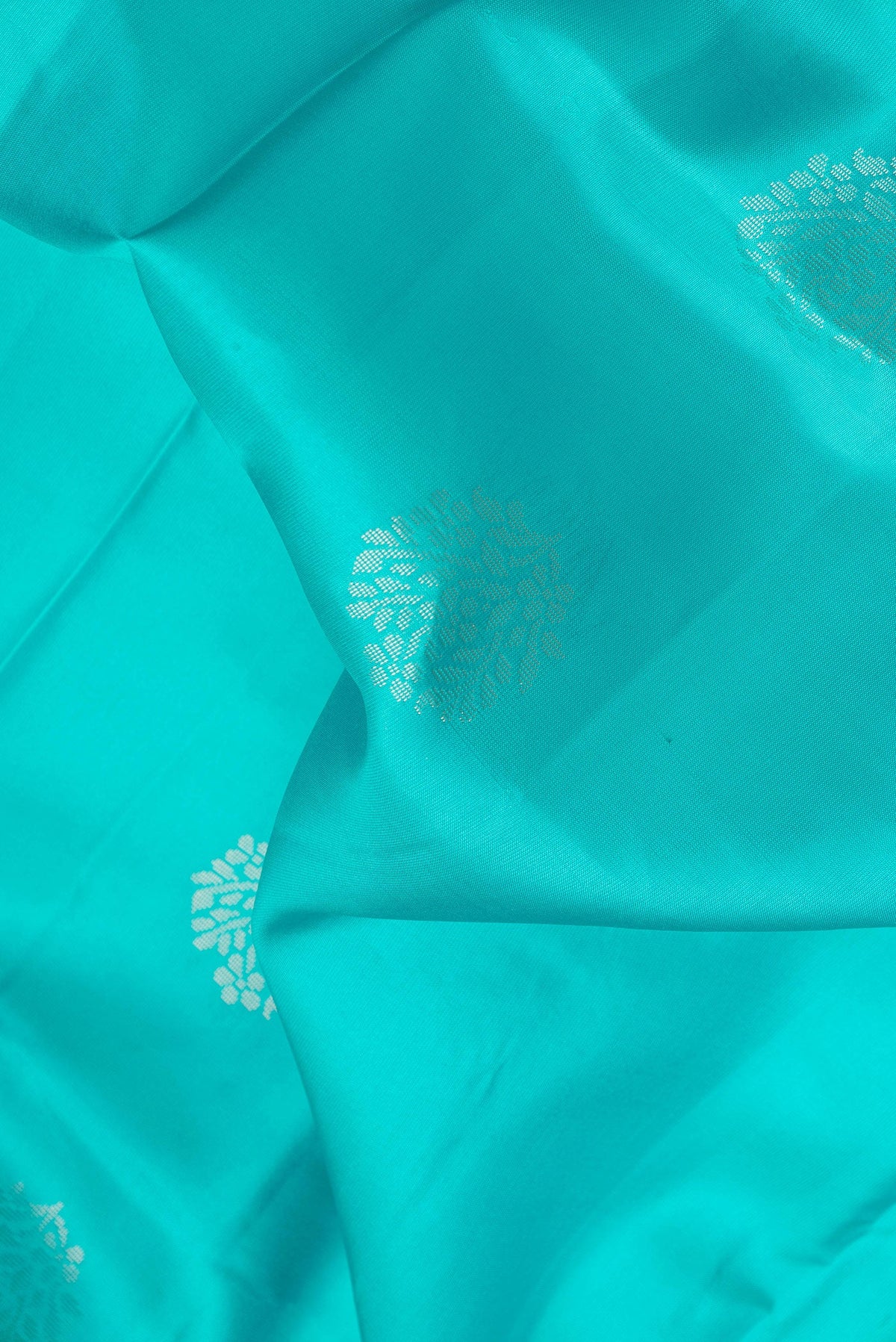 Close up of Sky Blue Dual Tone Soft Silk Saree with Zari Butta on the body and Fancy Border.  displaying folds