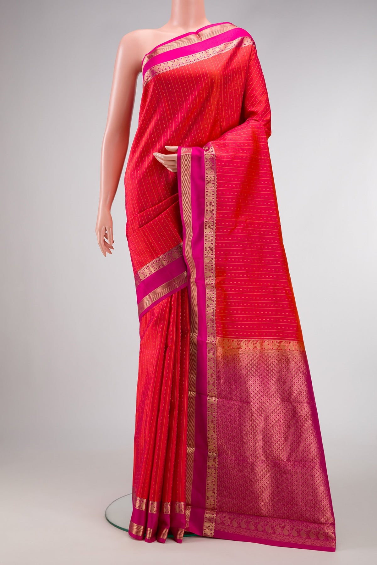 Orange Dual Tone Kanchipuram Silk Saree with Zari Butta on the body and Zari Border.  displayed on a mannequin