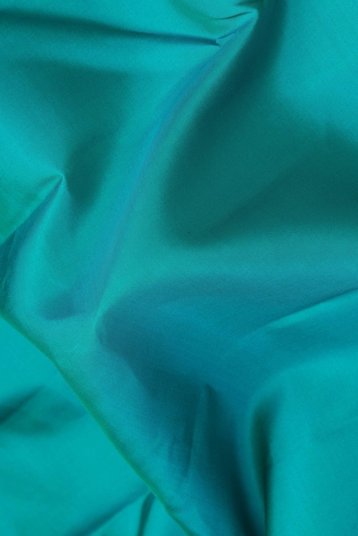 Close up of Peacock Blue Kanchipuram Silk Saree with Plain Body and Zari Border.  displaying folds
