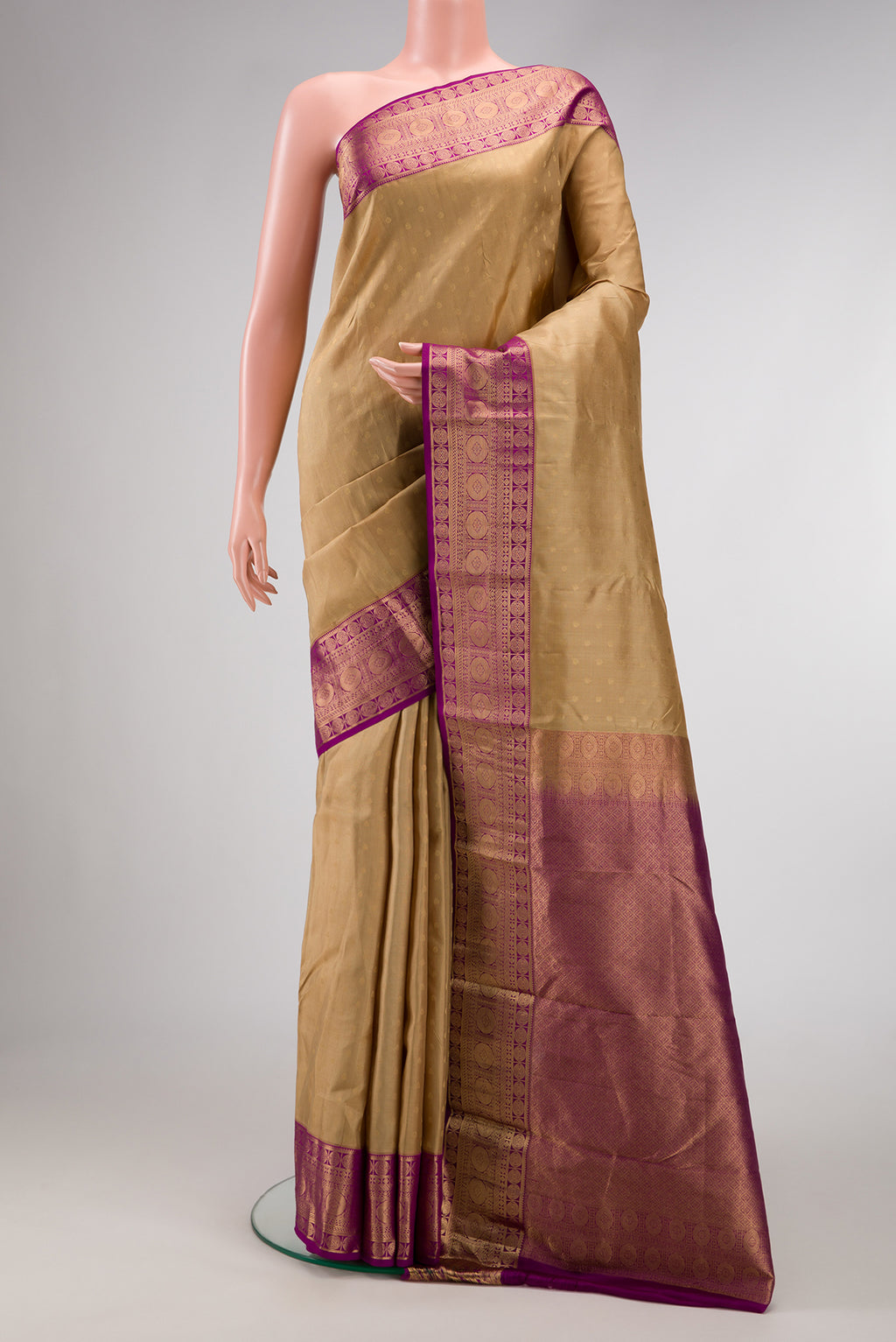 Beige Dual Tone Kanchipuram Silk Saree with Zari Butta on the body and Zari Border.  displayed on a mannequin