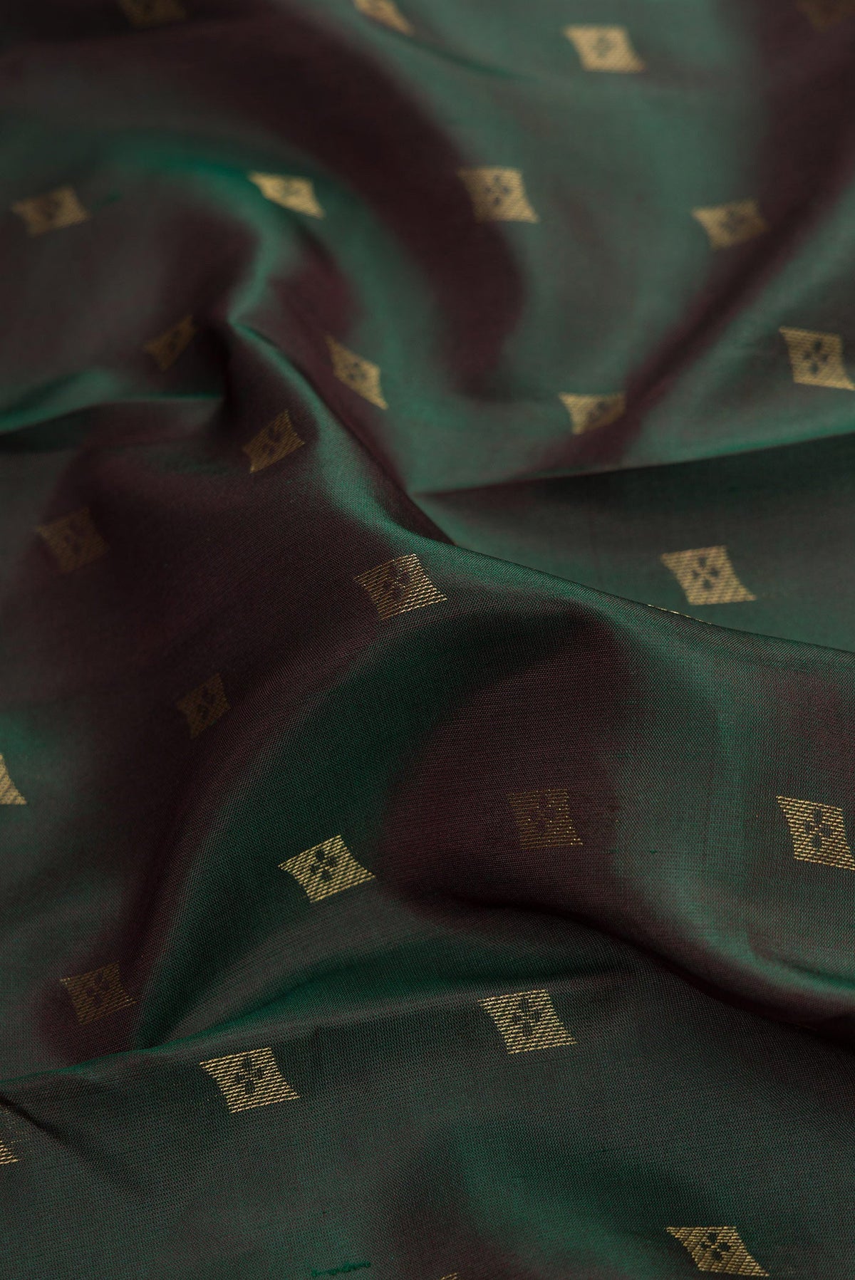 Close up of Bottle Green Dual Tone Kanchipuram Silk Saree with Zari Butta on the body and Zari Border.  displaying folds