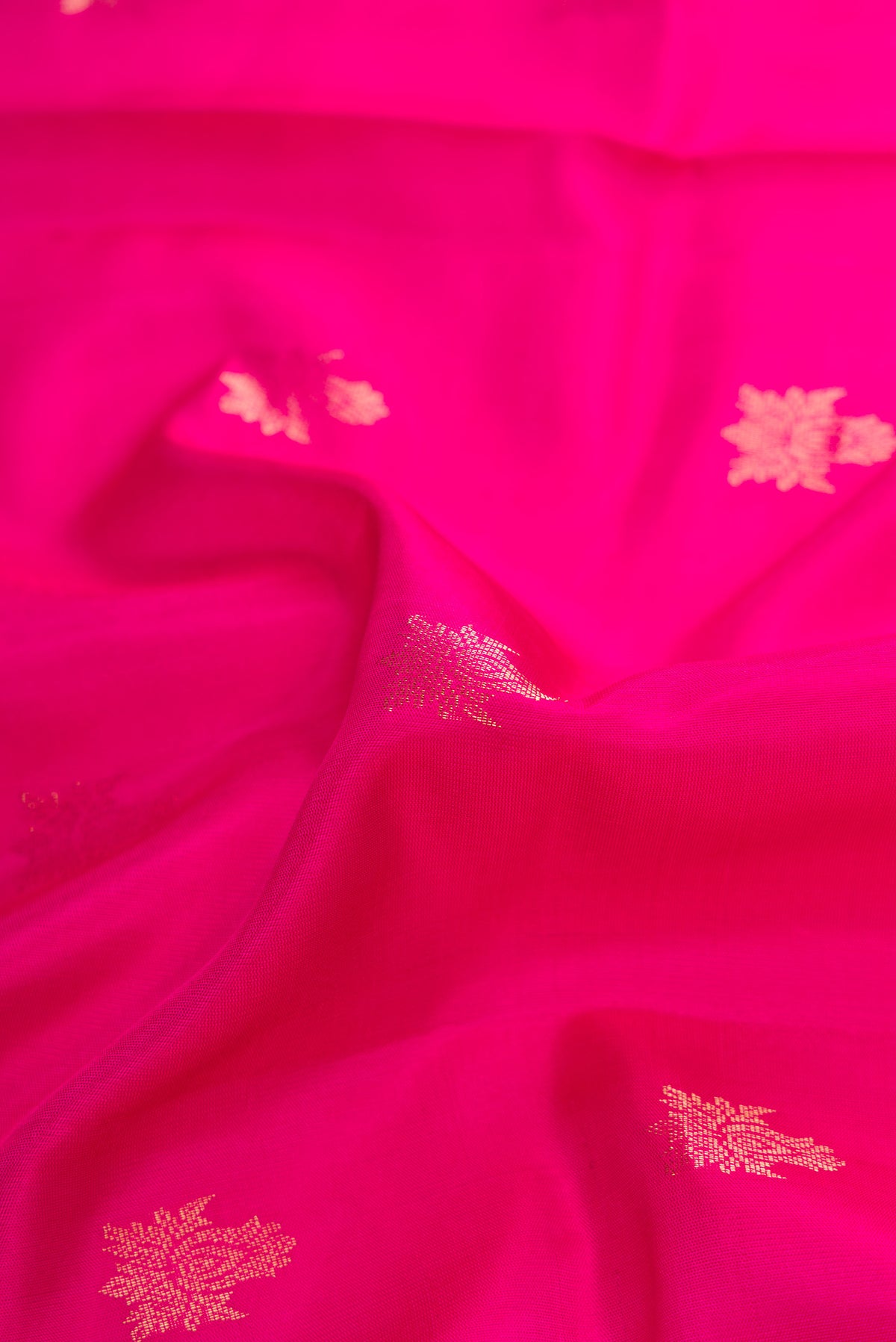 Close up of Pink Soft Silk Saree with Zari Butta on the body and Zari Border.  displaying folds