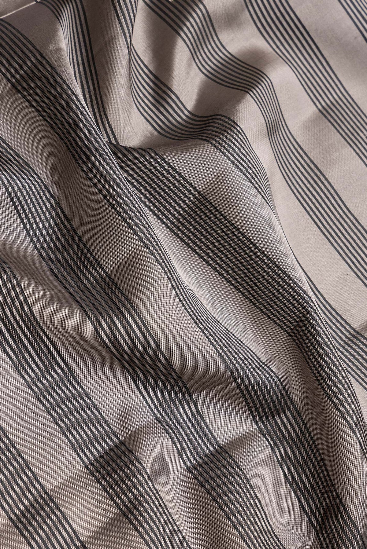 Close up of Grey Dual Tone Soft Silk Saree with Stripes on the body and Zari Border.  displaying folds
