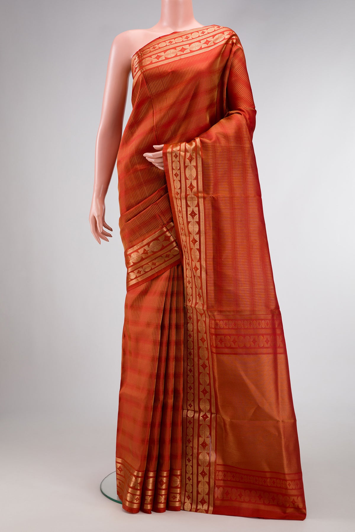 Rust Soft Silk Saree with Zari Butta on the body and Zari Border.  displayed on a mannequin
