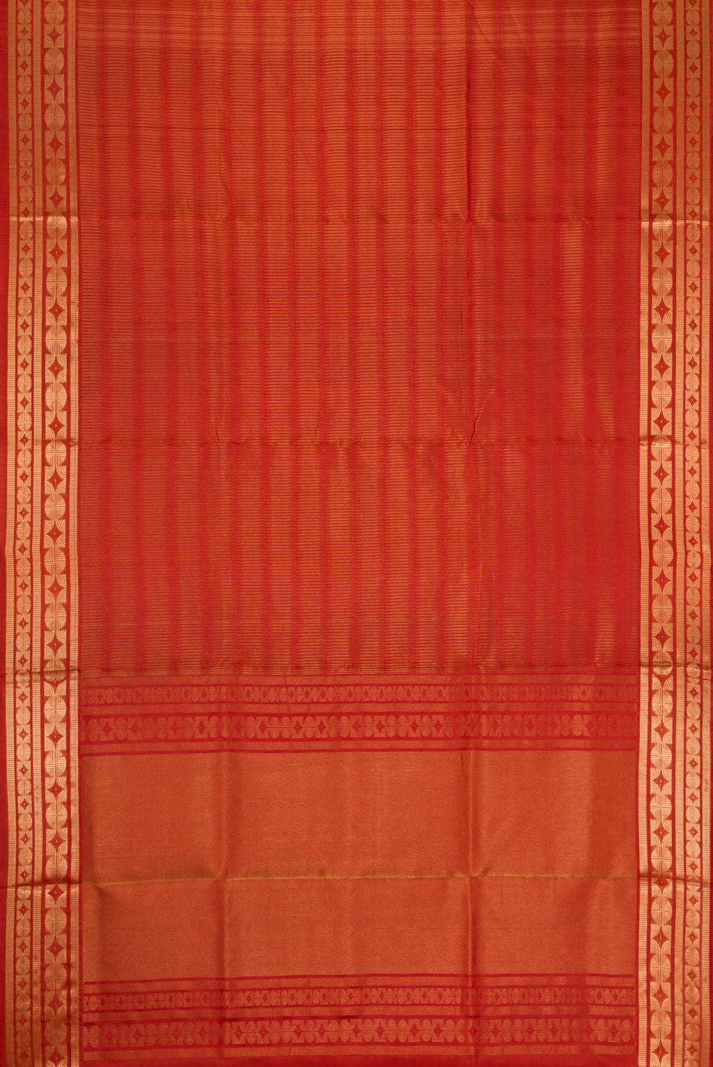 Flat view of Rust Soft Silk Saree with Zari Butta on the body and Zari Border. 