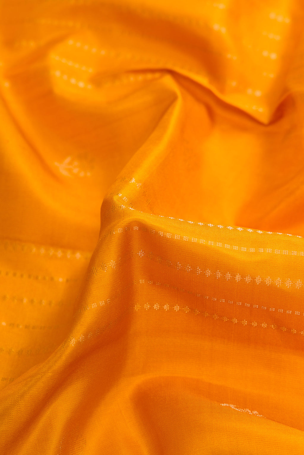 Close up of Yellow Soft Silk Saree with Stripes on the body and Zari Border.  displaying folds