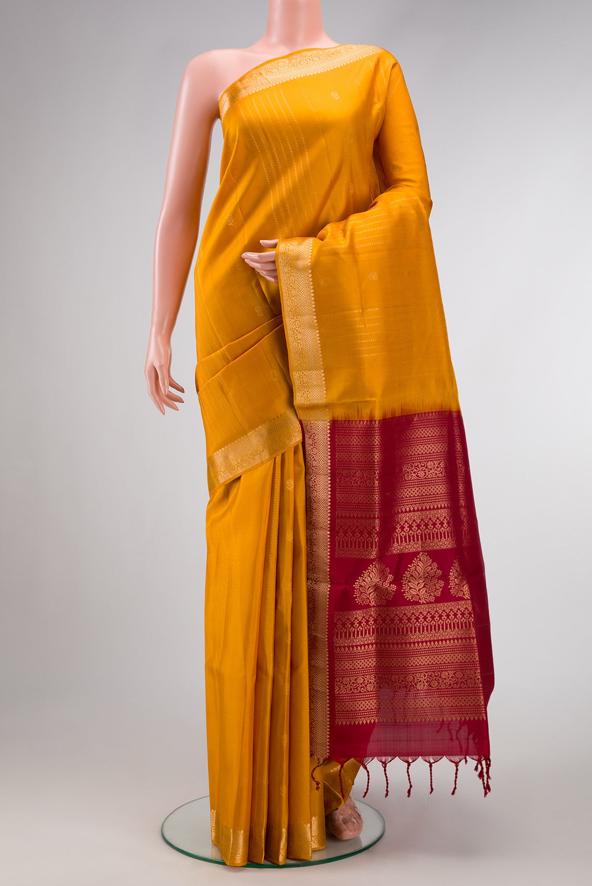 Yellow Soft Silk Saree with Stripes on the body and Zari Border.  displayed on a mannequin
