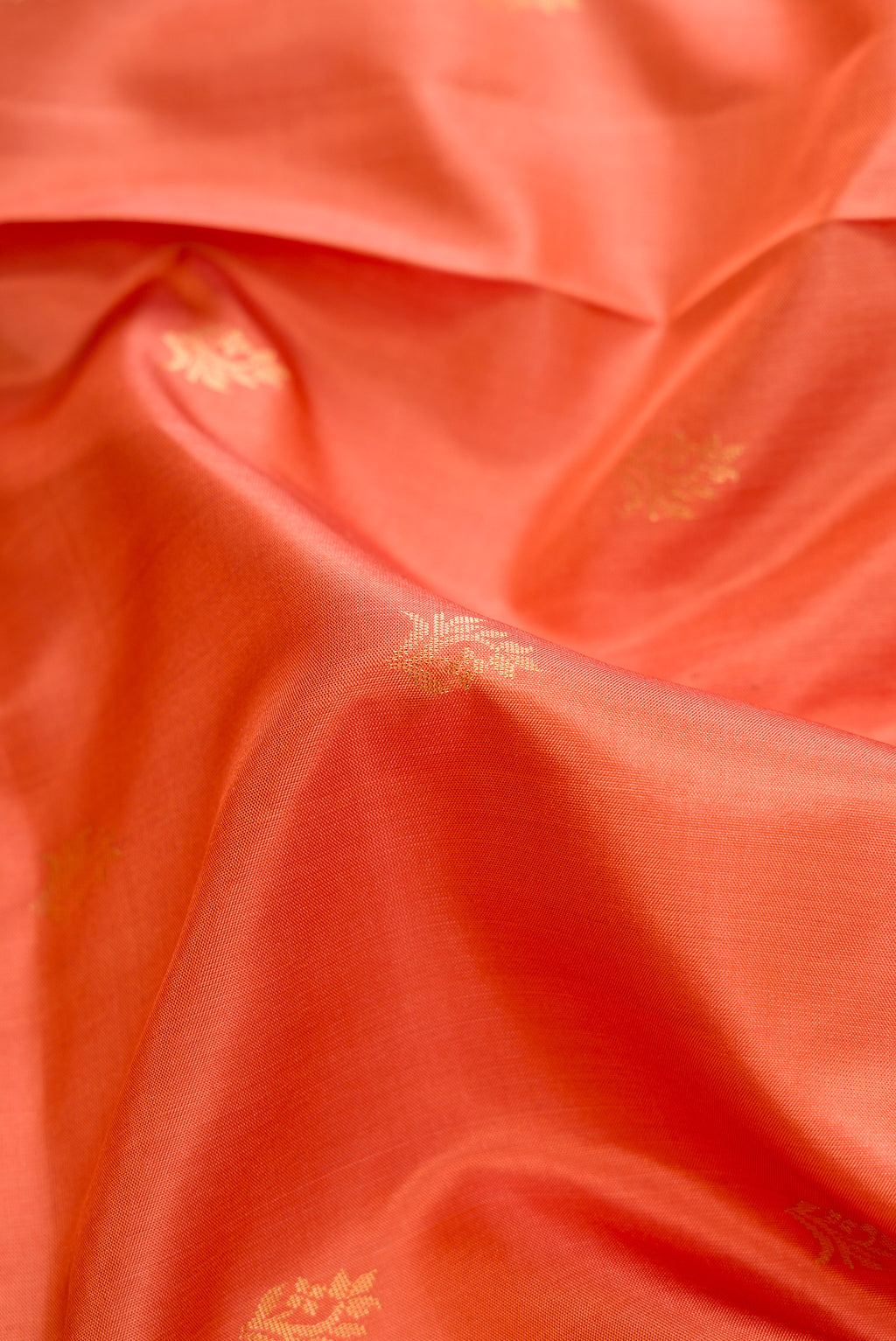 Close up of Peach Soft Silk Saree with Zari Butta on the body and Zari Border.  displaying folds