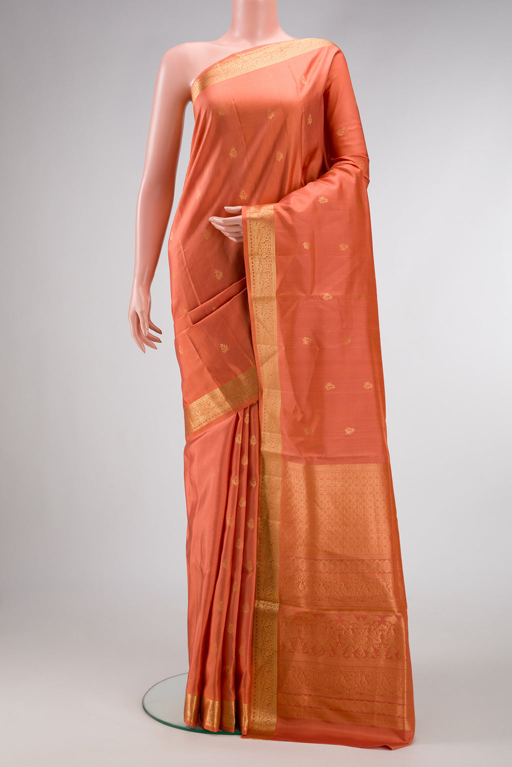 Peach Soft Silk Saree with Zari Butta on the body and Zari Border.  displayed on a mannequin