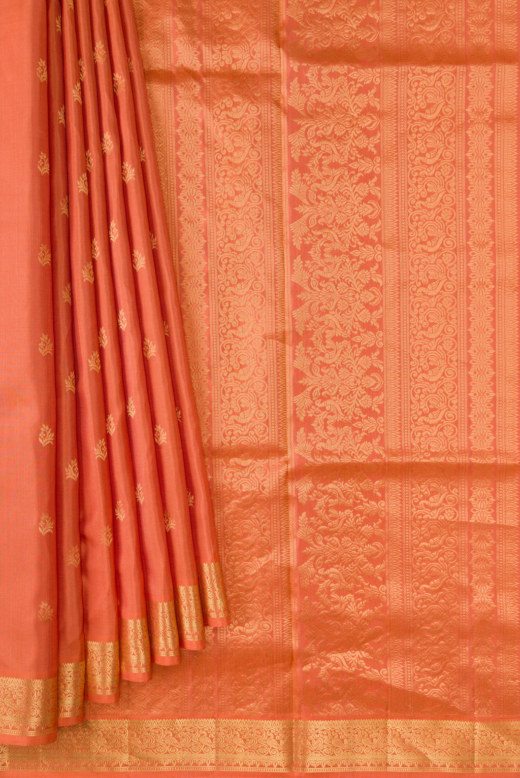 Pleats and pallu of Peach Soft Silk Saree with Zari Butta on the body and Zari Border. 