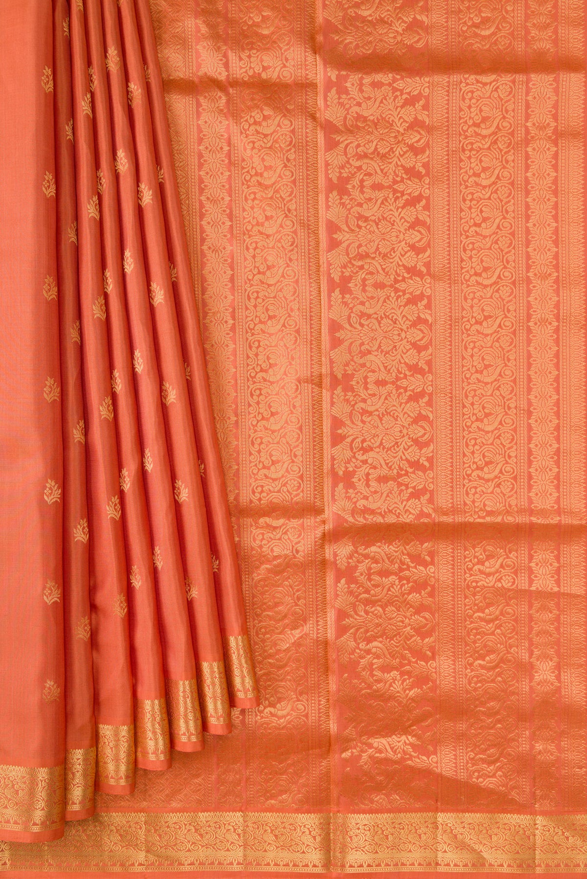 Pleats and pallu of Peach Soft Silk Saree with Zari Butta on the body and Zari Border. 