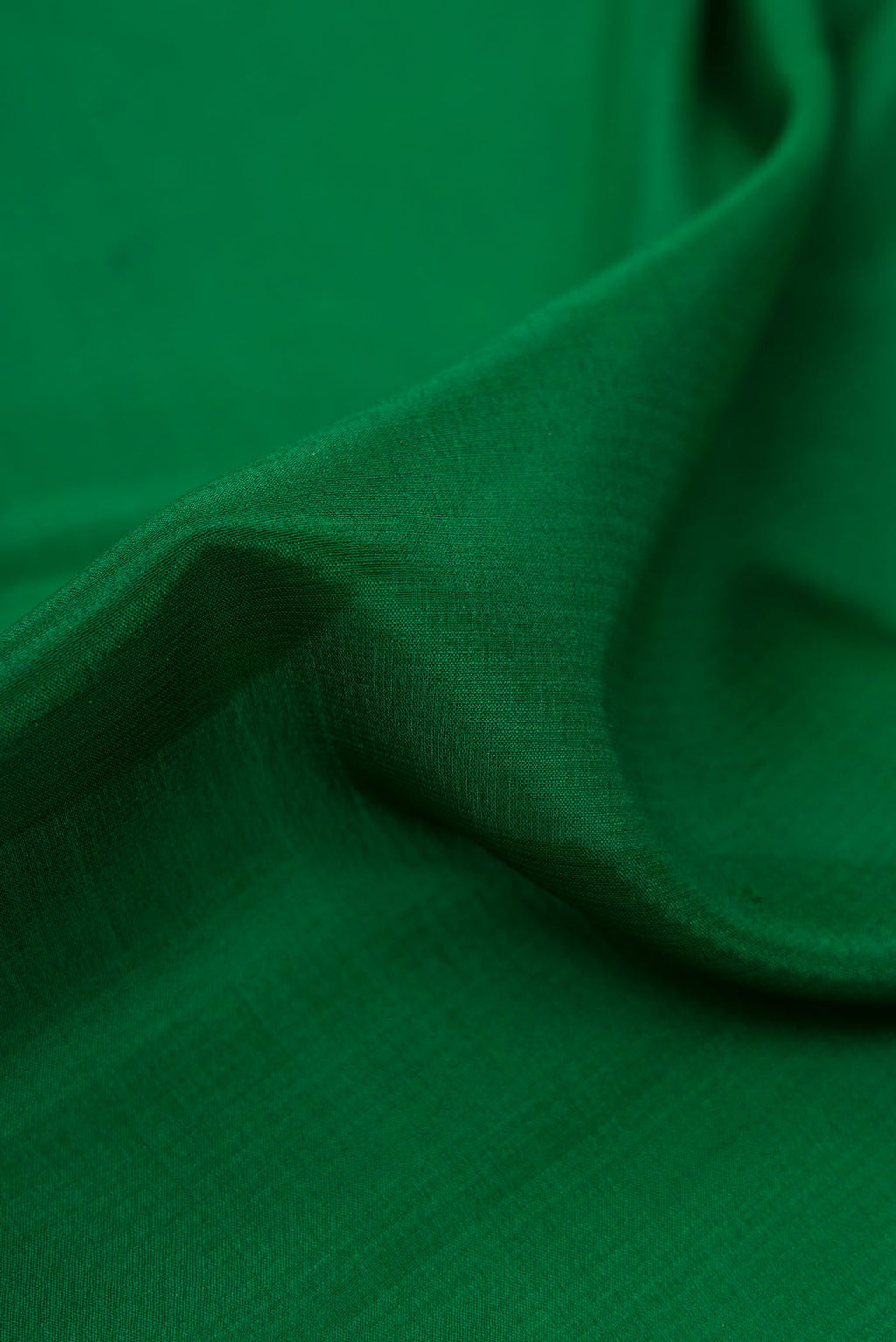Close up of Bottle Green Mysore Crepe Saree with Plain Body and Zari Border.  displaying folds