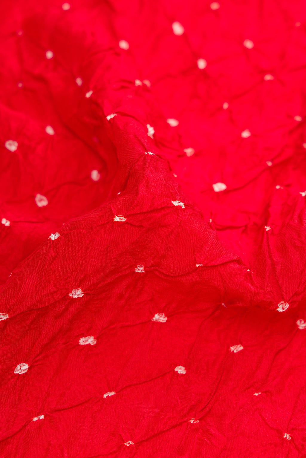 Close up of Red Bandhani Silk Saree with Bandhani Print on the body and Zari Border.  displaying folds