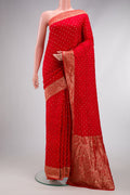 Red Bandhani Silk Saree with Bandhani Print on the body and Zari Border.  displayed on a mannequin