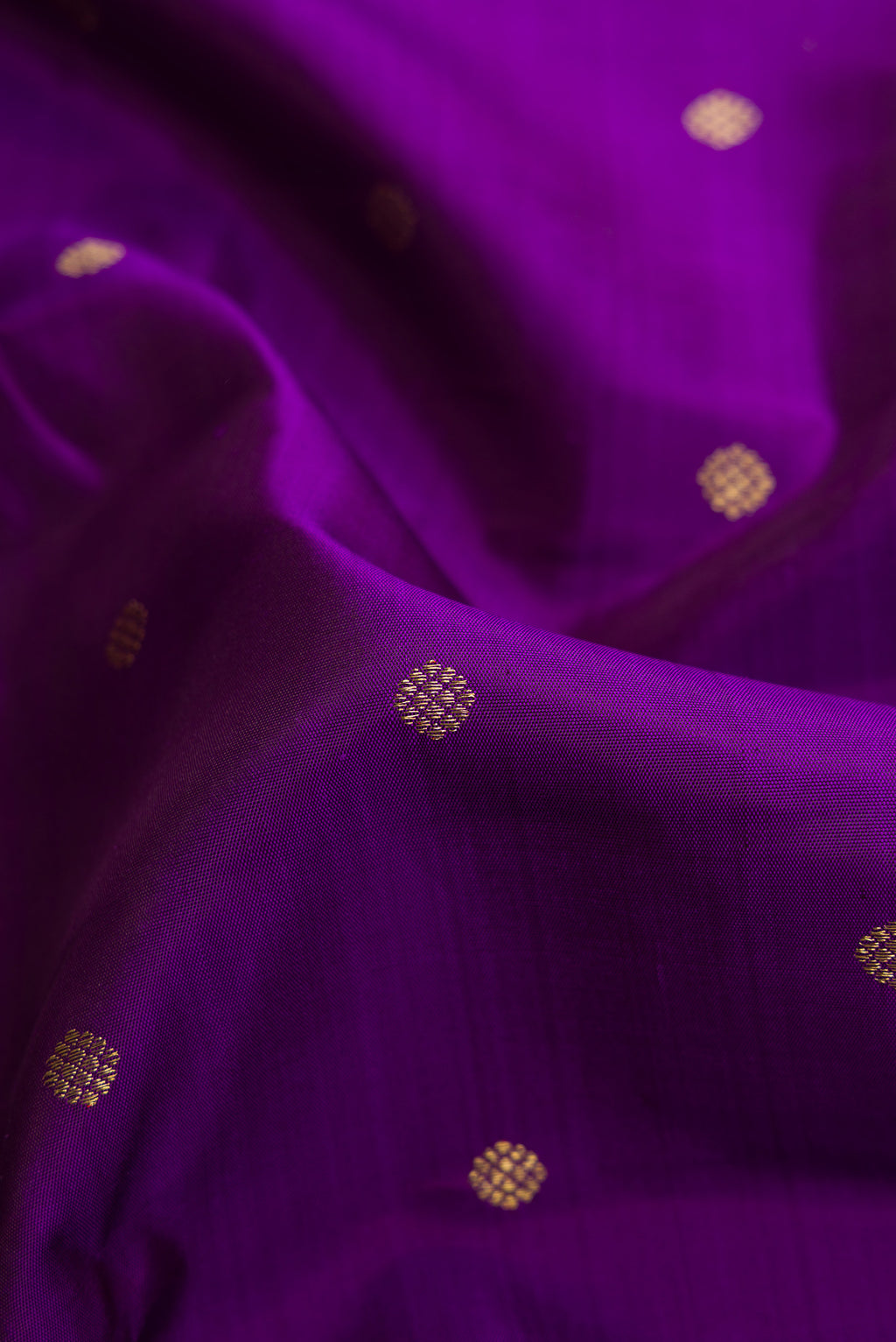 Close up of Pure Silk Pure Zari Violet Kanjivaram Saree with Zari Butta on the body and Zari Border.  displaying folds