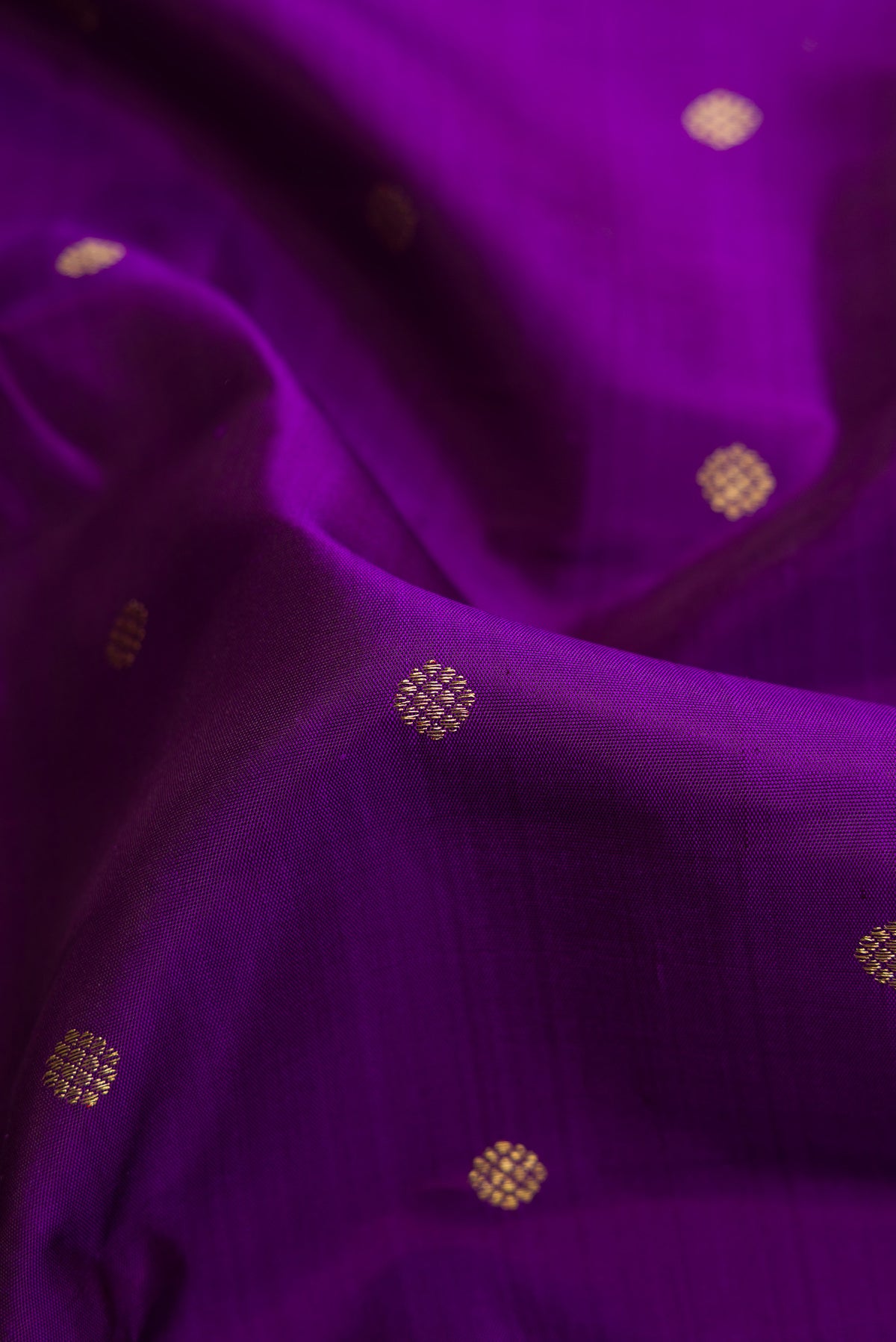 Close up of Pure Silk Pure Zari Violet Kanjivaram Saree with Zari Butta on the body and Zari Border.  displaying folds
