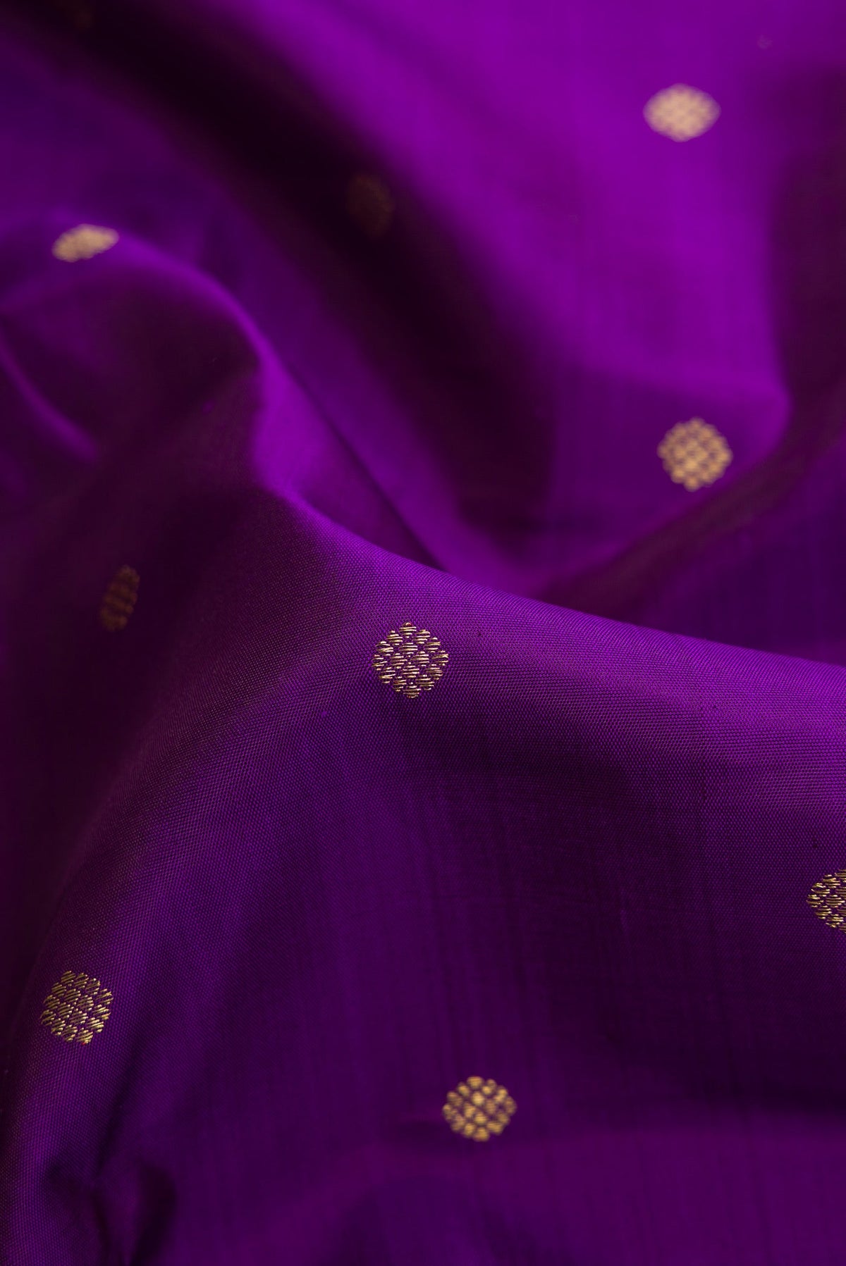 Close up of Violet Dual Tone Kanjivaram Silk Saree with Zari Butta on the body and Zari Border.  displaying folds