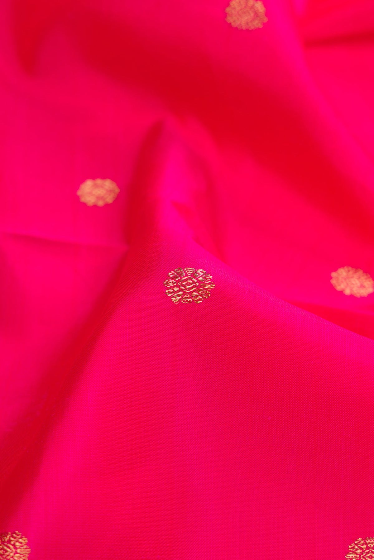 Close up of Pure Silk Pure Zari Pink Dual Tone Kanjivaram Saree with Zari Butta on the body and Zari Border.  displaying folds