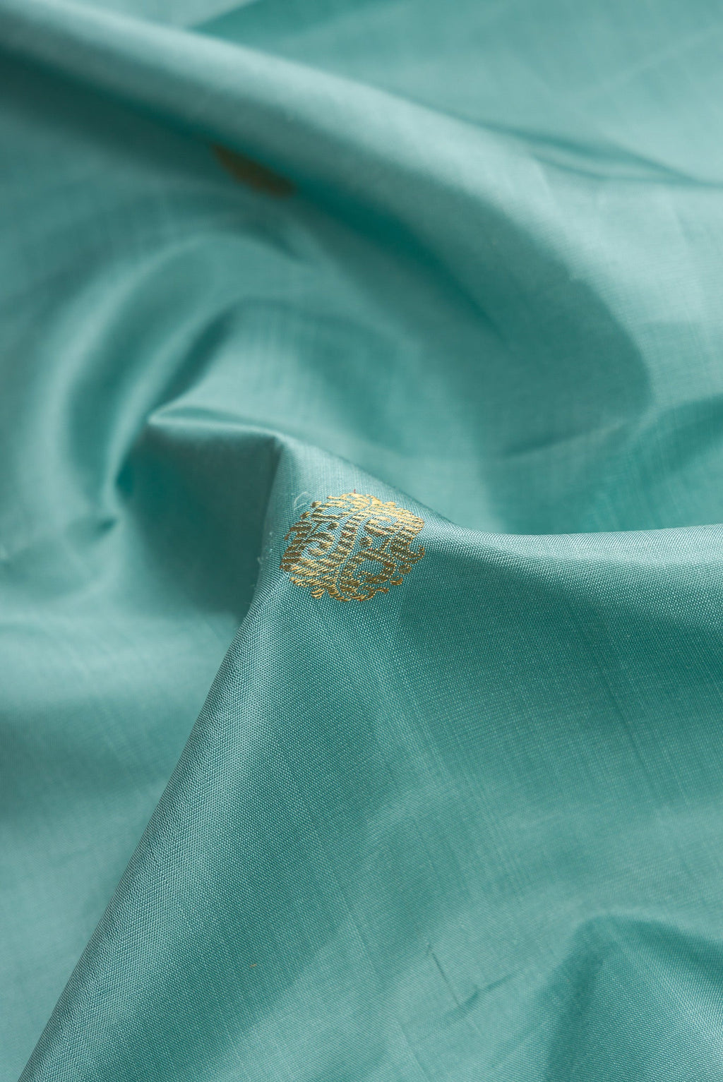 Close up of Pure Silk Pure Zari Sky Blue Dual Tone Kanjivaram Saree with Zari Butta on the body and Zari Border.  displaying folds