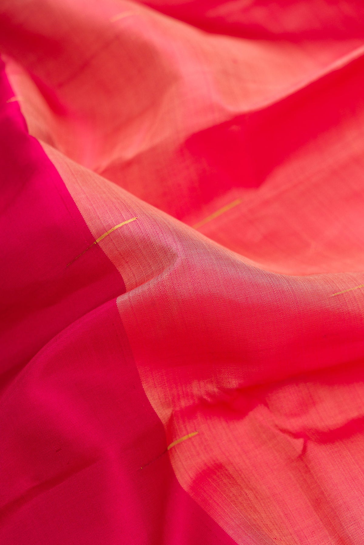 Close up of Peach and Dark Pink Color Kanjivaram Silk Saree with Half And Half on the body and Without Border.  displaying folds
