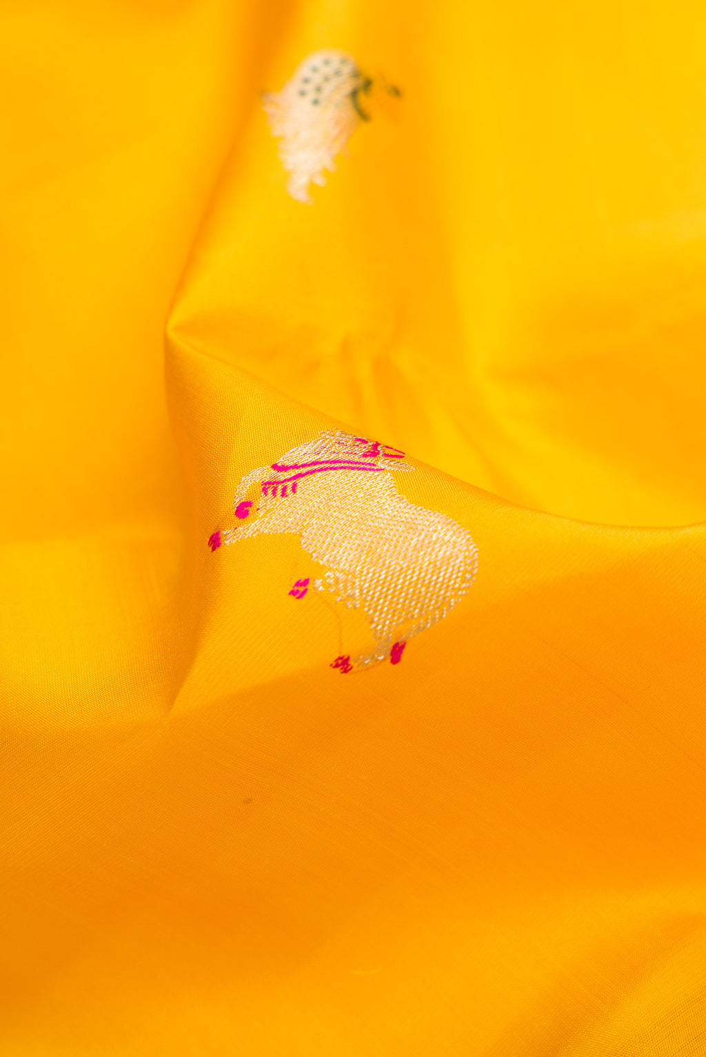 Close up of Yellow Kanjivaram Silk Saree with Zari And Thread Butta on the body and Thin Zari Line.  displaying folds