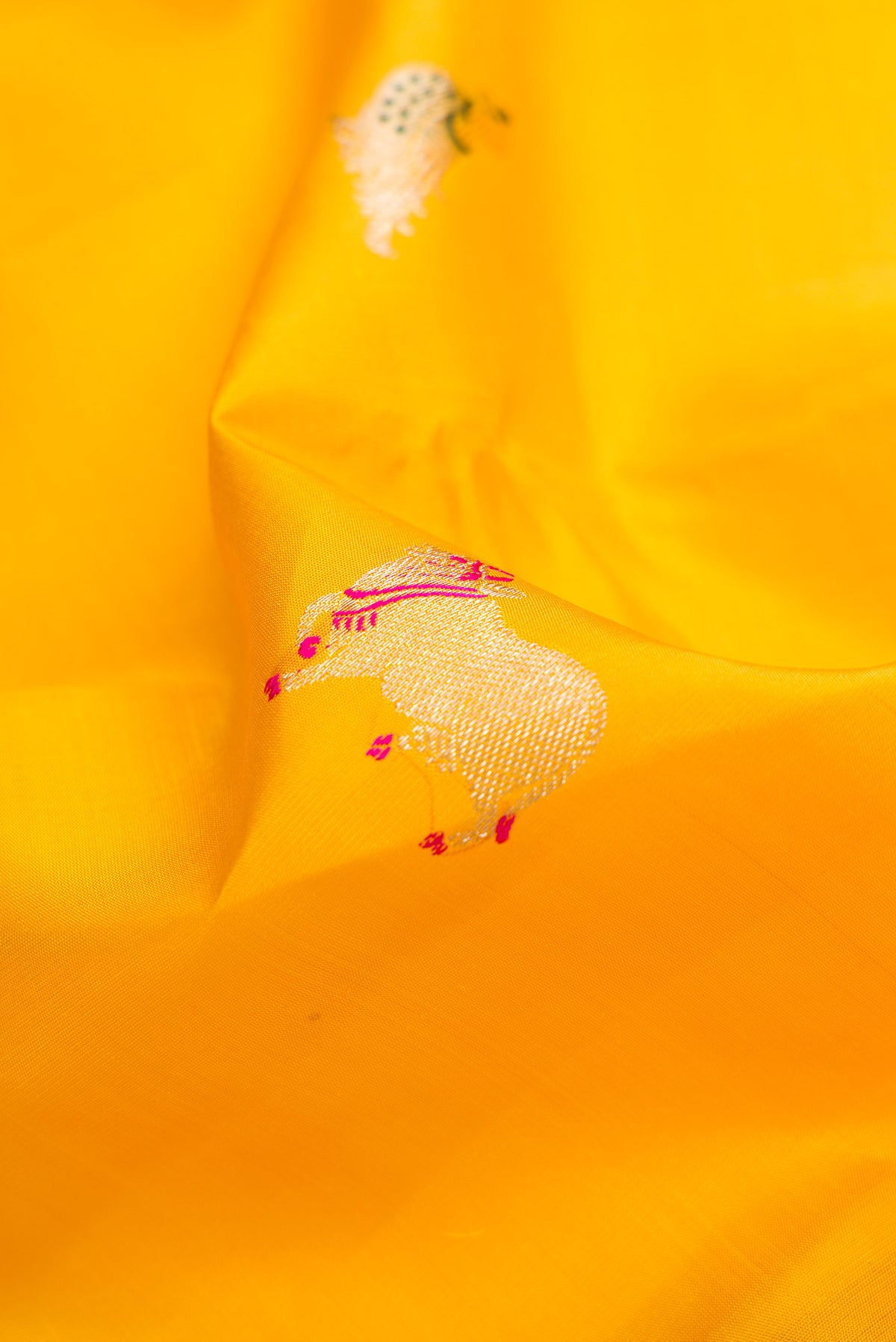 Close up of Yellow Kanjivaram Silk Saree with Zari And Thread Butta on the body and Thin Zari Line.  displaying folds