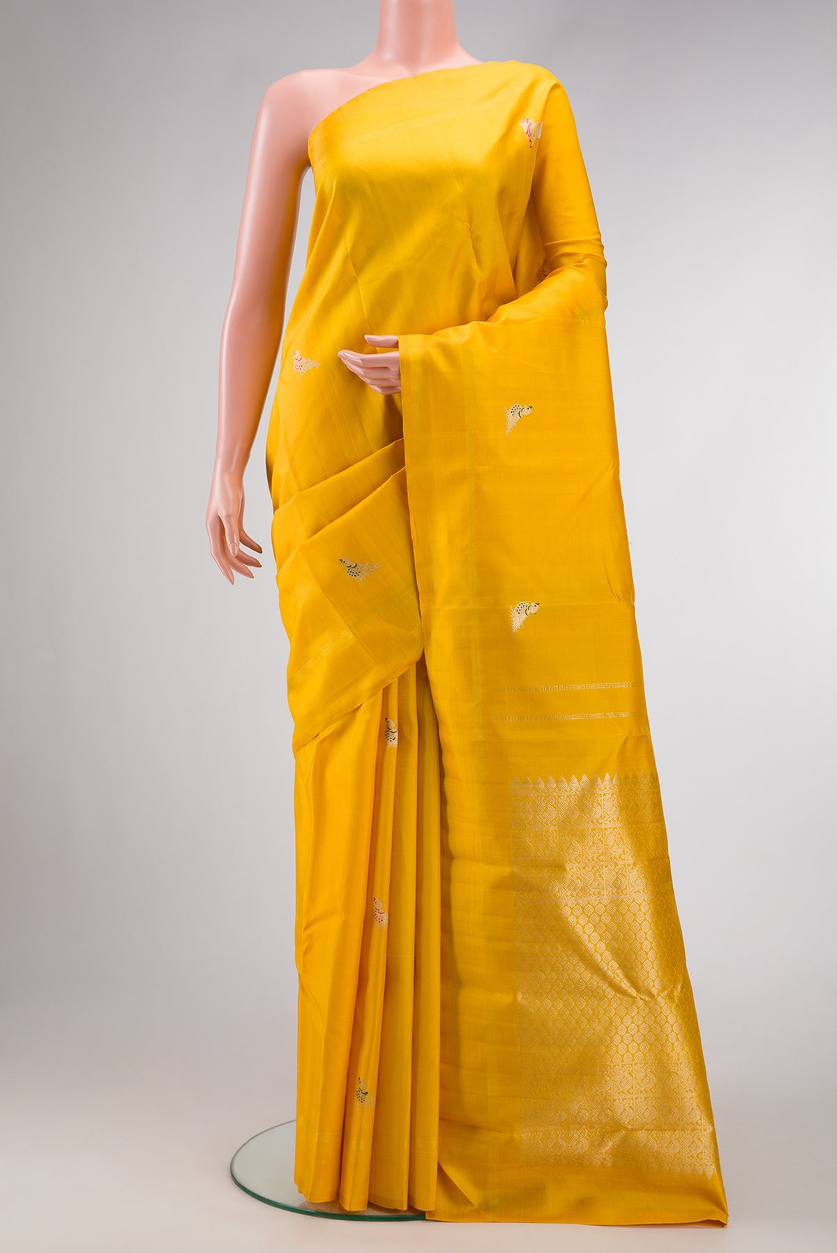 Yellow Kanjivaram Silk Saree with Zari And Thread Butta on the body and Thin Zari Line.  displayed on a mannequin