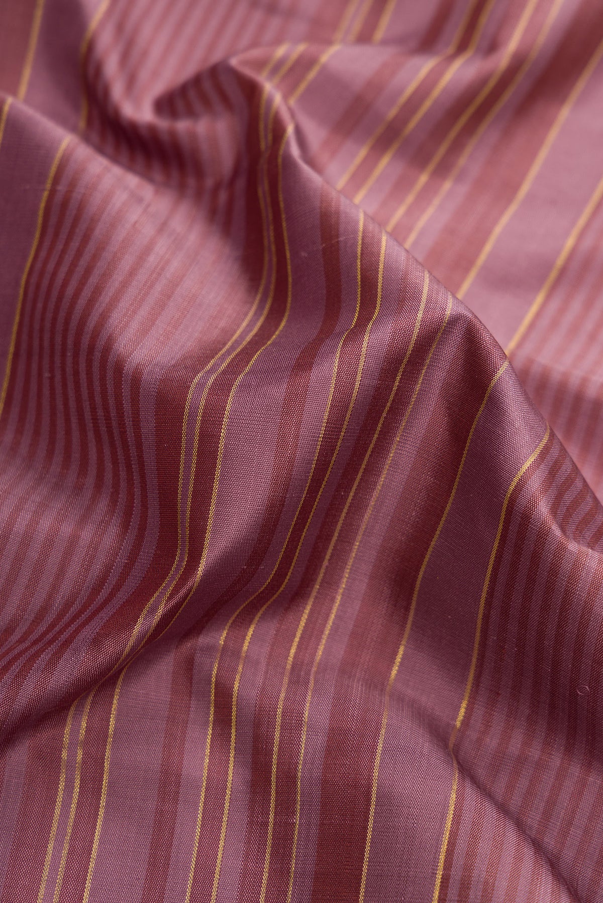 Close up of Mauve Kanjivaram Silk Saree with Stripes on the body and Plain Border.  displaying folds