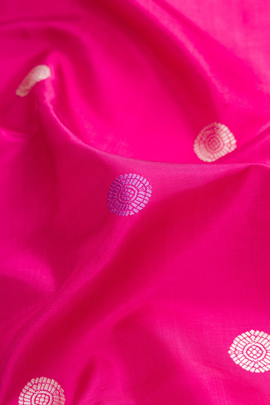 Close up of Pink Kanjivaram Silk Saree with Thread Butta on the body and Zari Border.  displaying folds