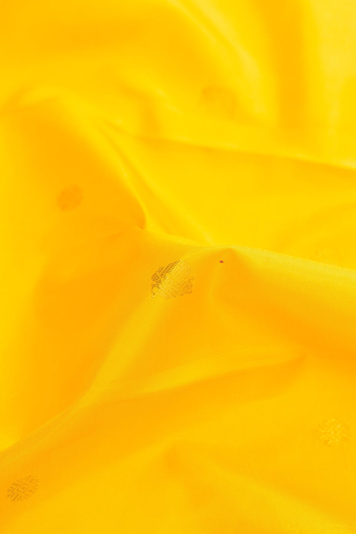 Close up of Pure Silk Pure Zari Yellow Dual Tone Kanjivaram Saree with Zari Butta on the body and Zari Border.  displaying folds