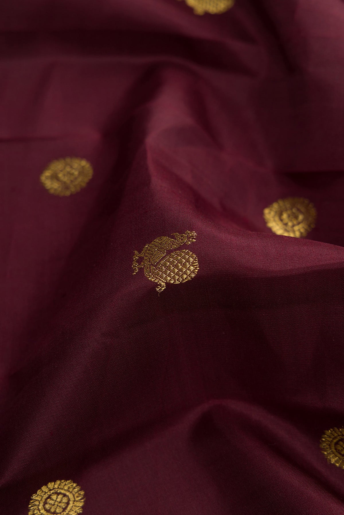 Close up of Coffee Brown Dual Tone Kanjivaram Silk Saree with Zari Butta on the body and Zari Border.  displaying folds
