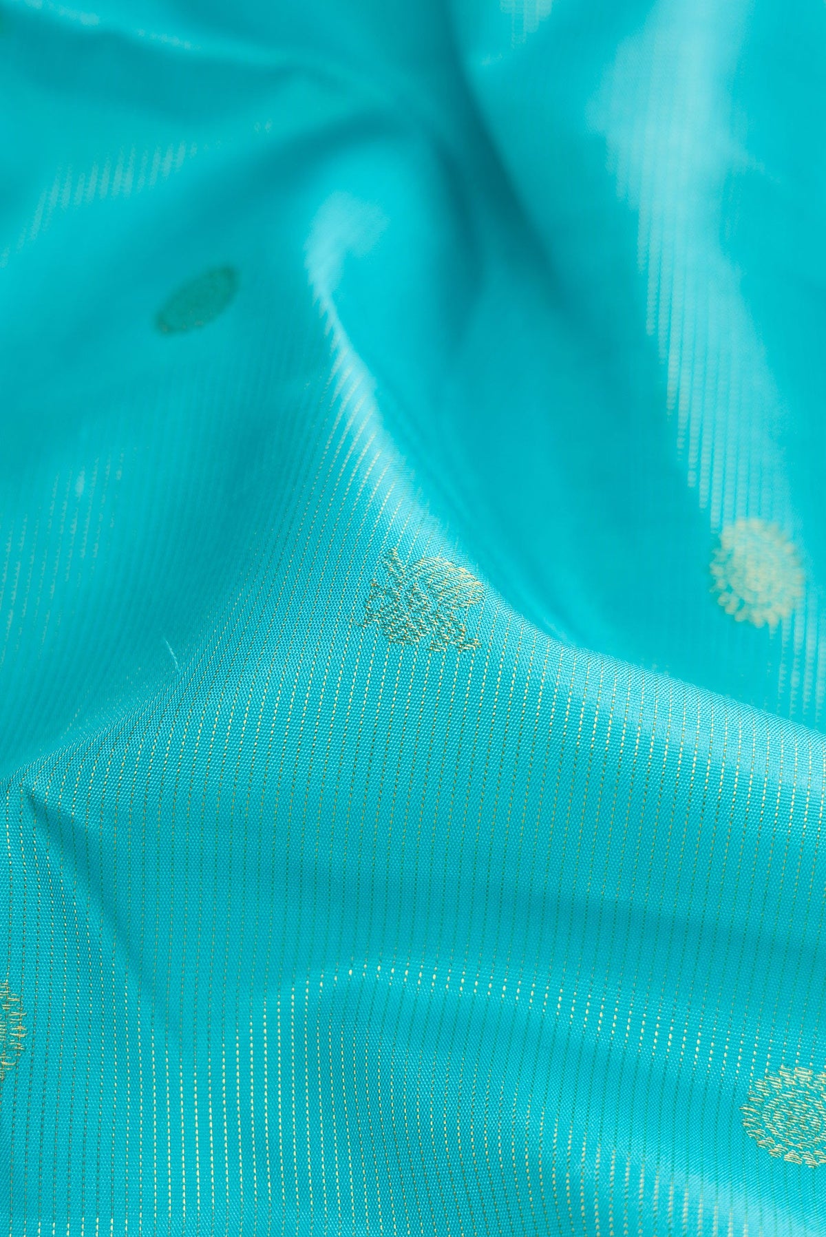 Close up of Sky Blue Dual Tone Kanchipuram Silk Saree with Zari Butta on the body and Zari And Thread Border.  displaying folds