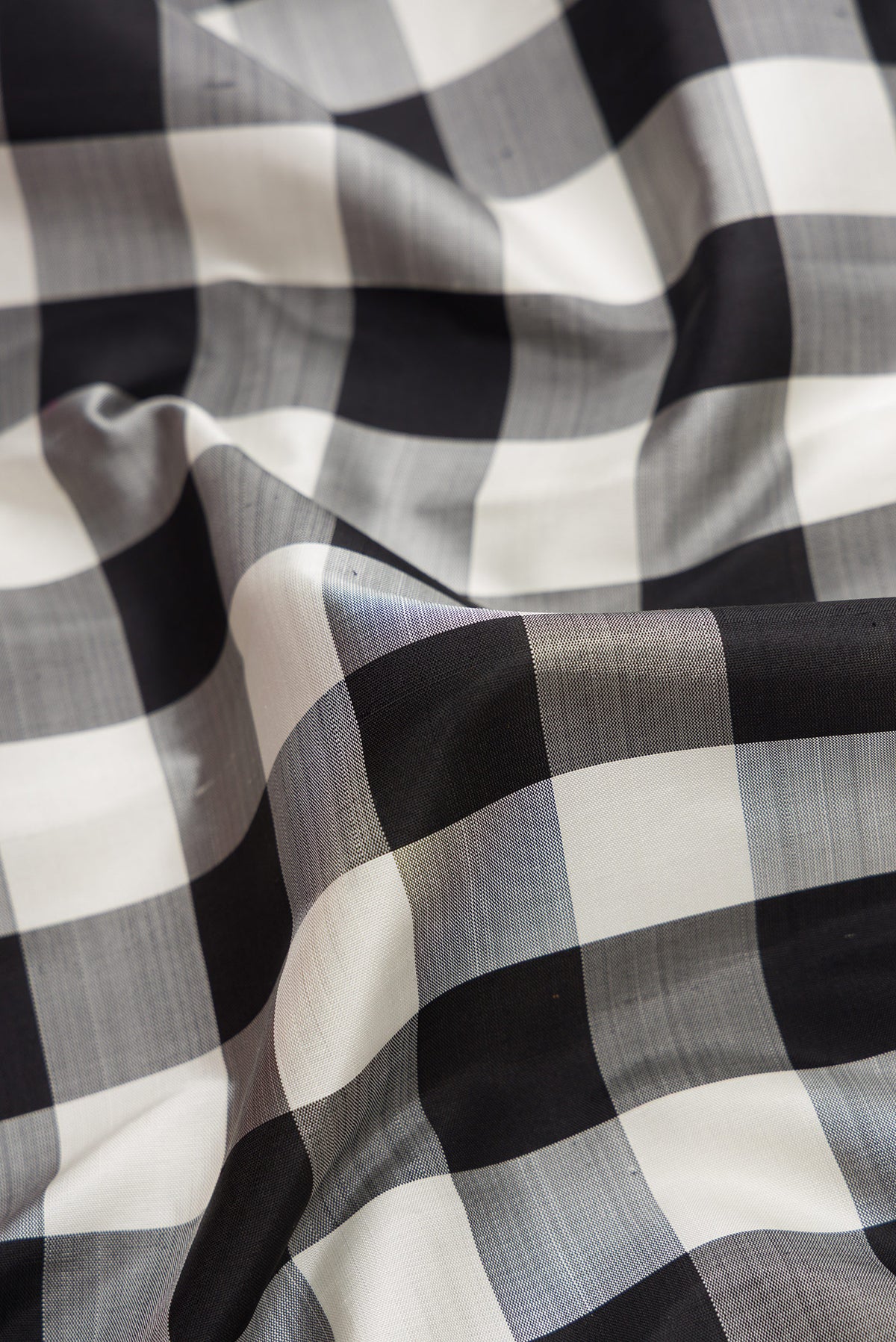 Close up of White and Black Color Kanjivaram Silk Saree with Checked design on the body and Zari Border.  displaying folds