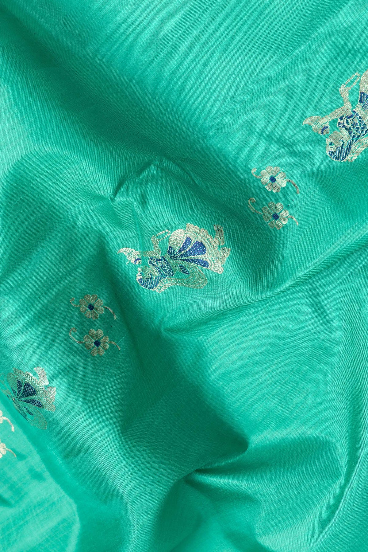 Close up of Sea Green Dual Tone Baluchari Silk Saree with Zari And Thread Butta on the body and Fancy Border.  displaying folds
