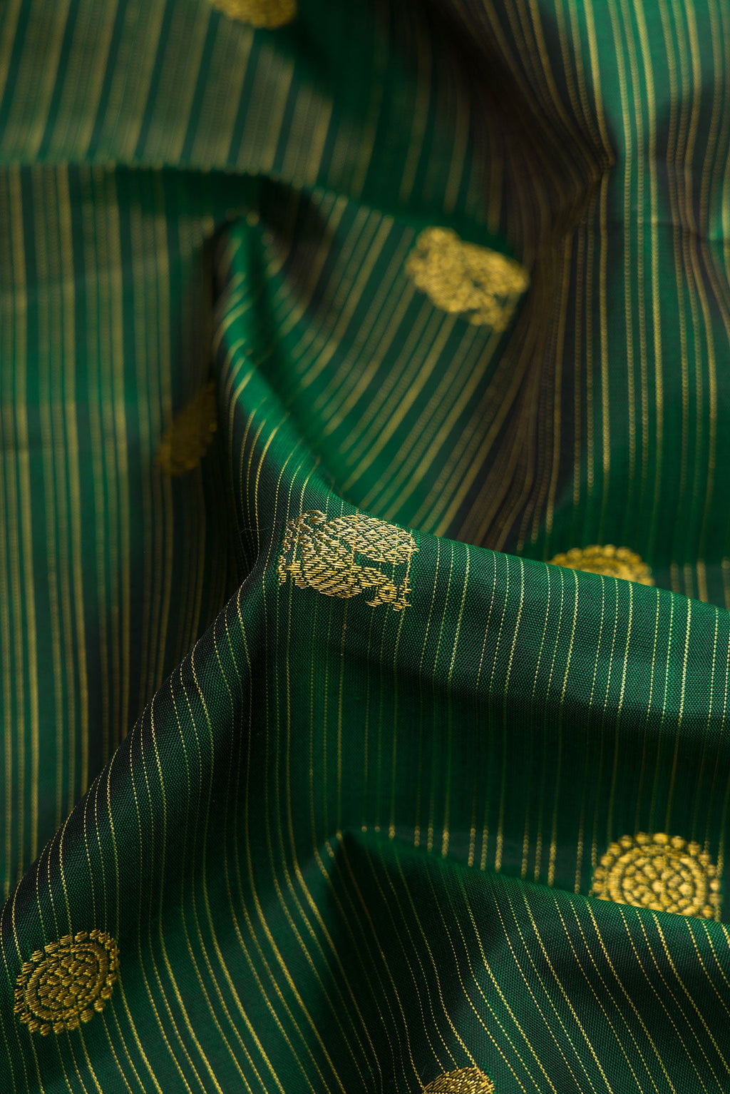 Close up of Green Dual Tone Kanchipuram Silk Saree with Zari Butta on the body and Zari Border.  displaying folds