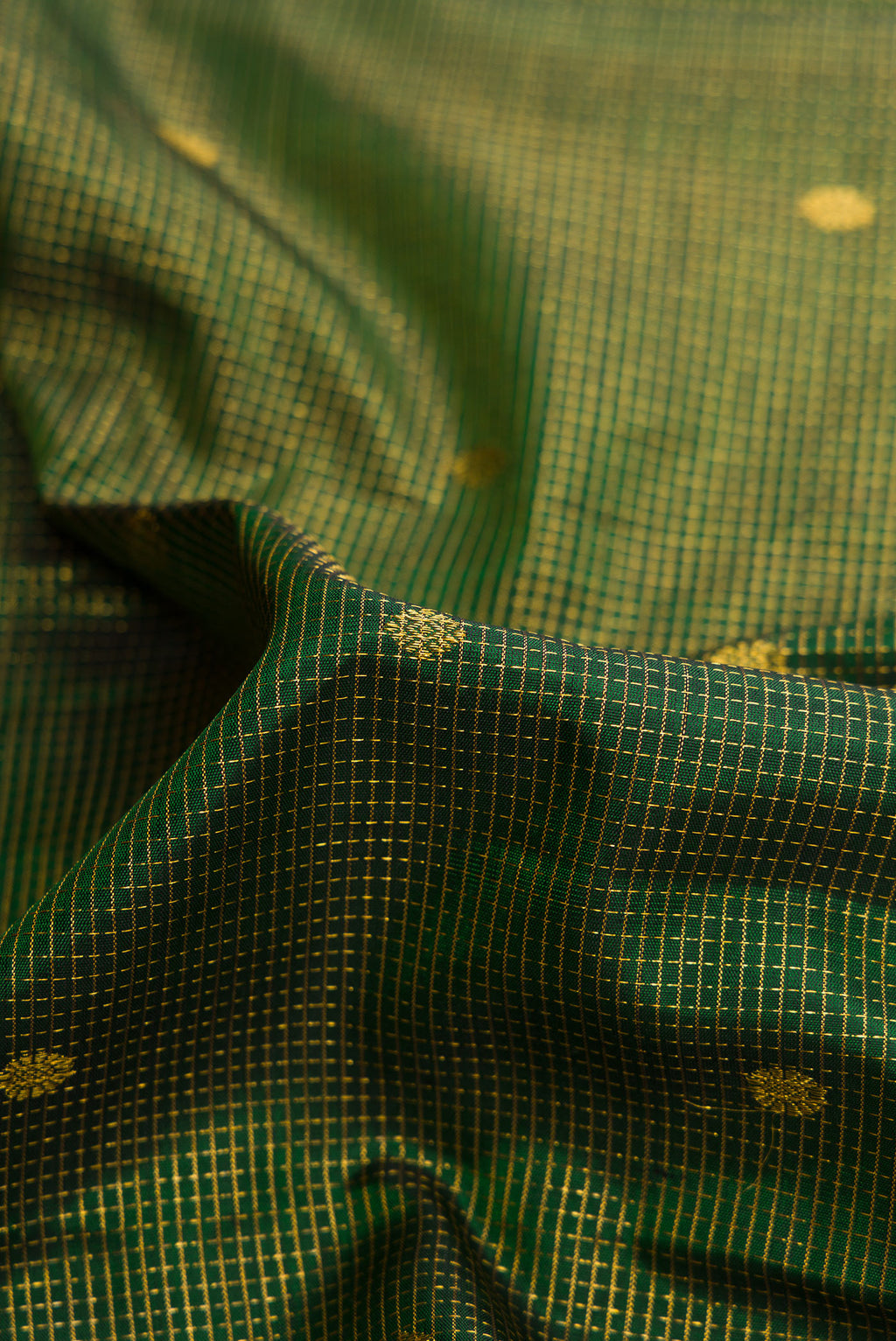 Close up of Bottle Green Dual Tone Kanjivaram Silk Saree with Checked design on the body and Fancy Border.  displaying folds