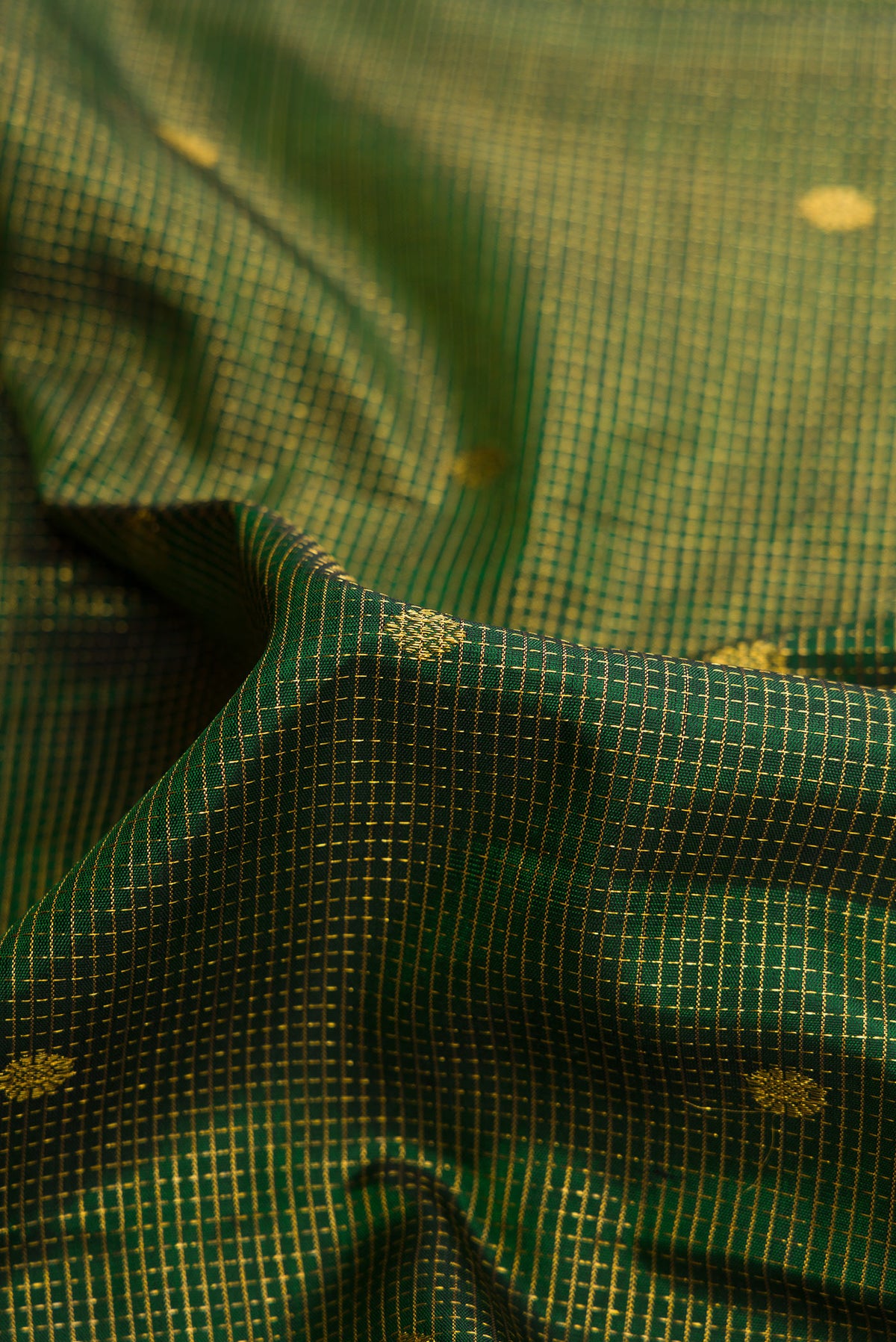 Close up of Bottle Green Dual Tone Kanjivaram Silk Saree with Checked design on the body and Fancy Border.  displaying folds