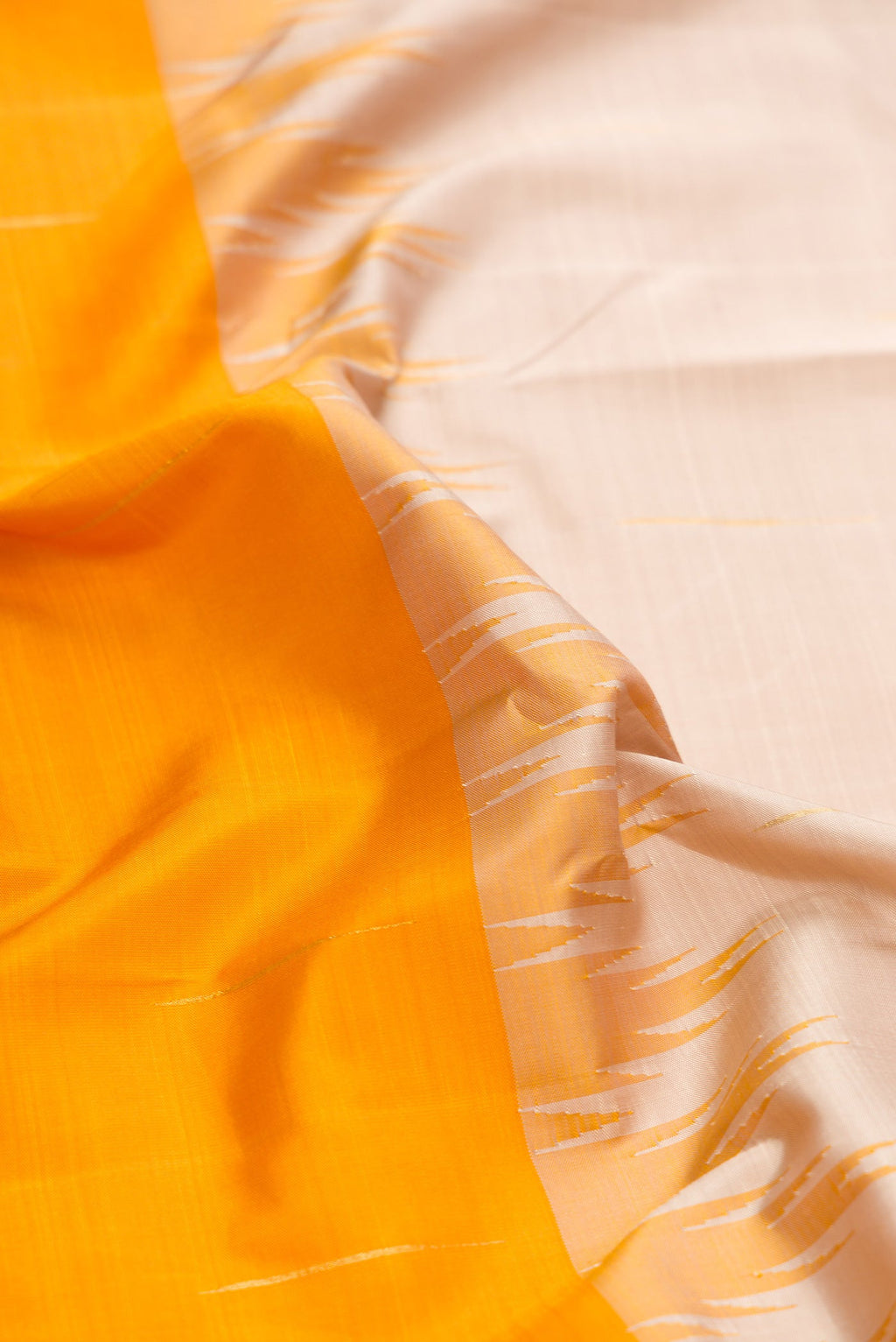 Close up of Beige and Mustard Color Kanjivaram Silk Saree with Half And Half on the body and Thin Zari Line.  displaying folds