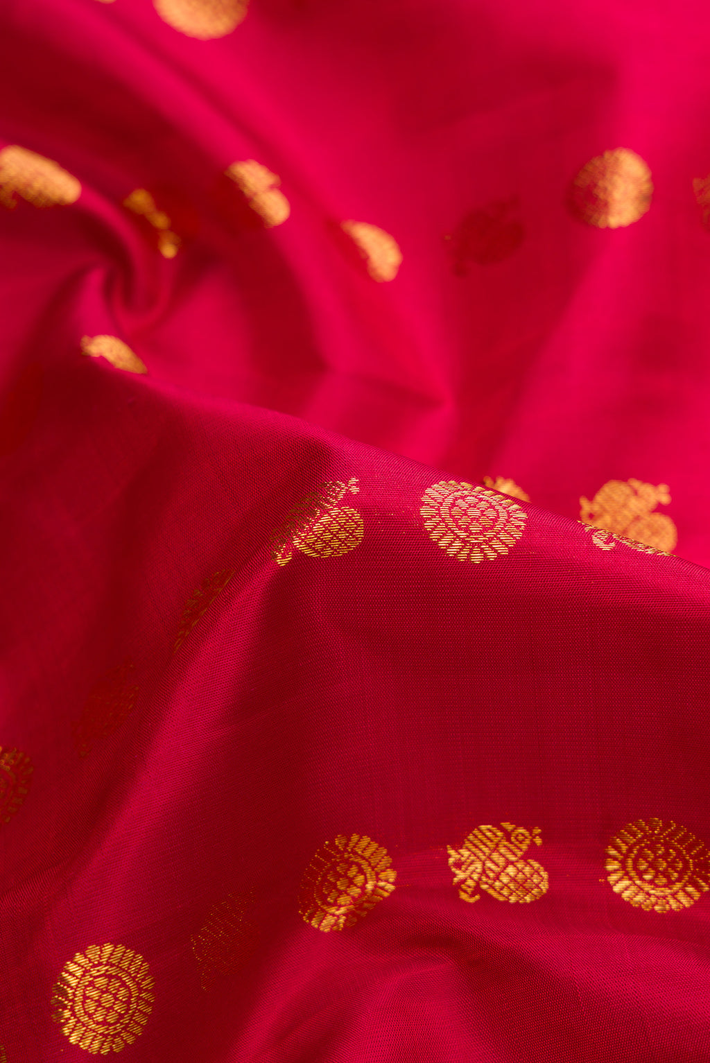Close up of Maroon Kanjivaram Silk Saree with Zari Butta on the body and Fancy Border.  displaying folds