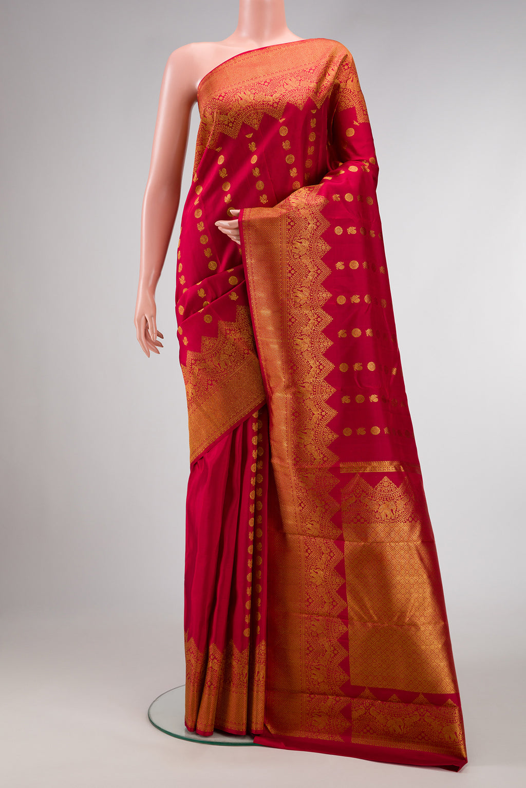 Maroon Kanjivaram Silk Saree with Zari Butta on the body and Fancy Border.  displayed on a mannequin