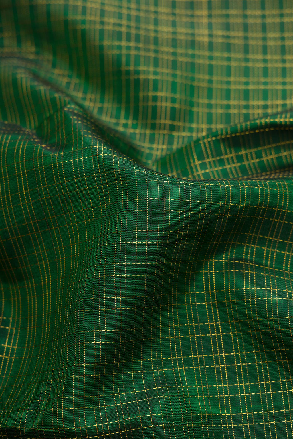 Close up of Bottle Green Kanchipuram Silk Saree with Checked design on the body and Zari Border.  displaying folds