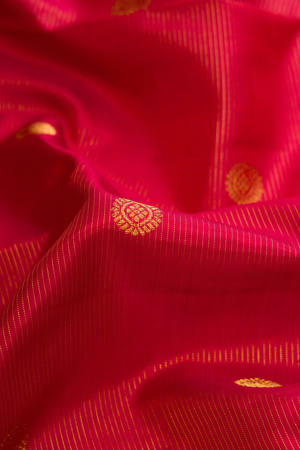 Close up of Red Kanchipuram Silk Saree with Zari Butta on the body and Zari Border.  displaying folds