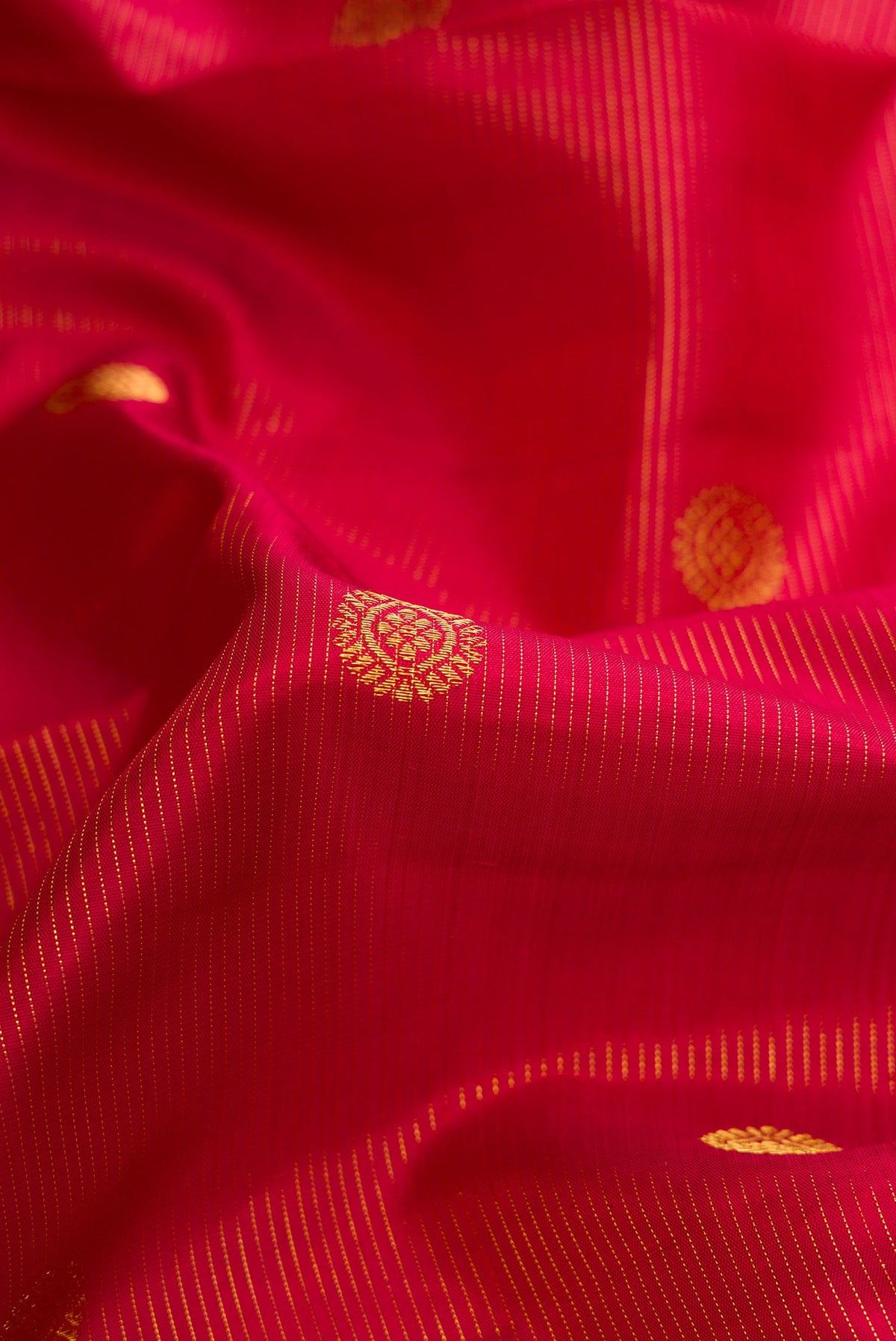 Close up of Maroon Dual Tone Kanchipuram Silk Saree with Zari Butta on the body and Zari Border.  displaying folds