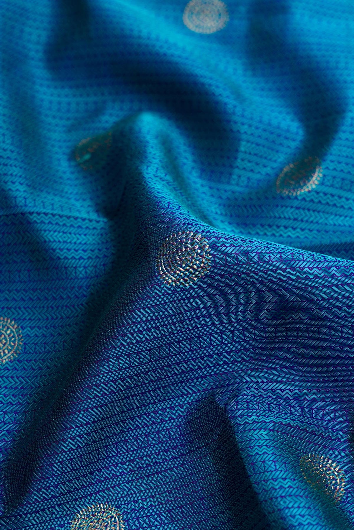 Close up of Peacock Blue Dual Tone Kanchipuram Silk Saree with Jacquard With Zari Butta on the body and Zari Border.  displaying folds