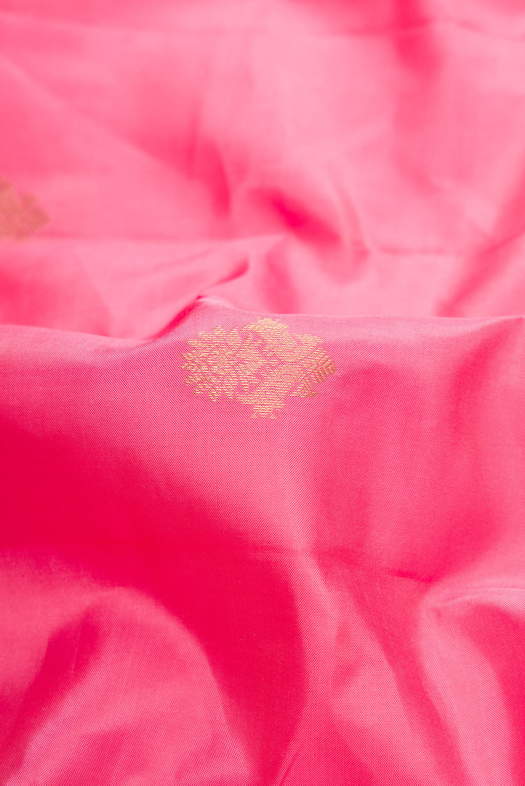 Close up of Pink Kanchipuram Silk Saree with Zari Butta on the body and Zari Border.  displaying folds