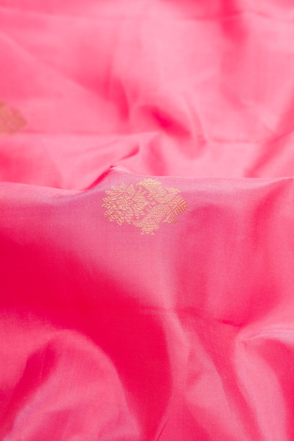 Close up of Pink Kanchipuram Silk Saree with Zari Butta on the body and Zari Border.  displaying folds
