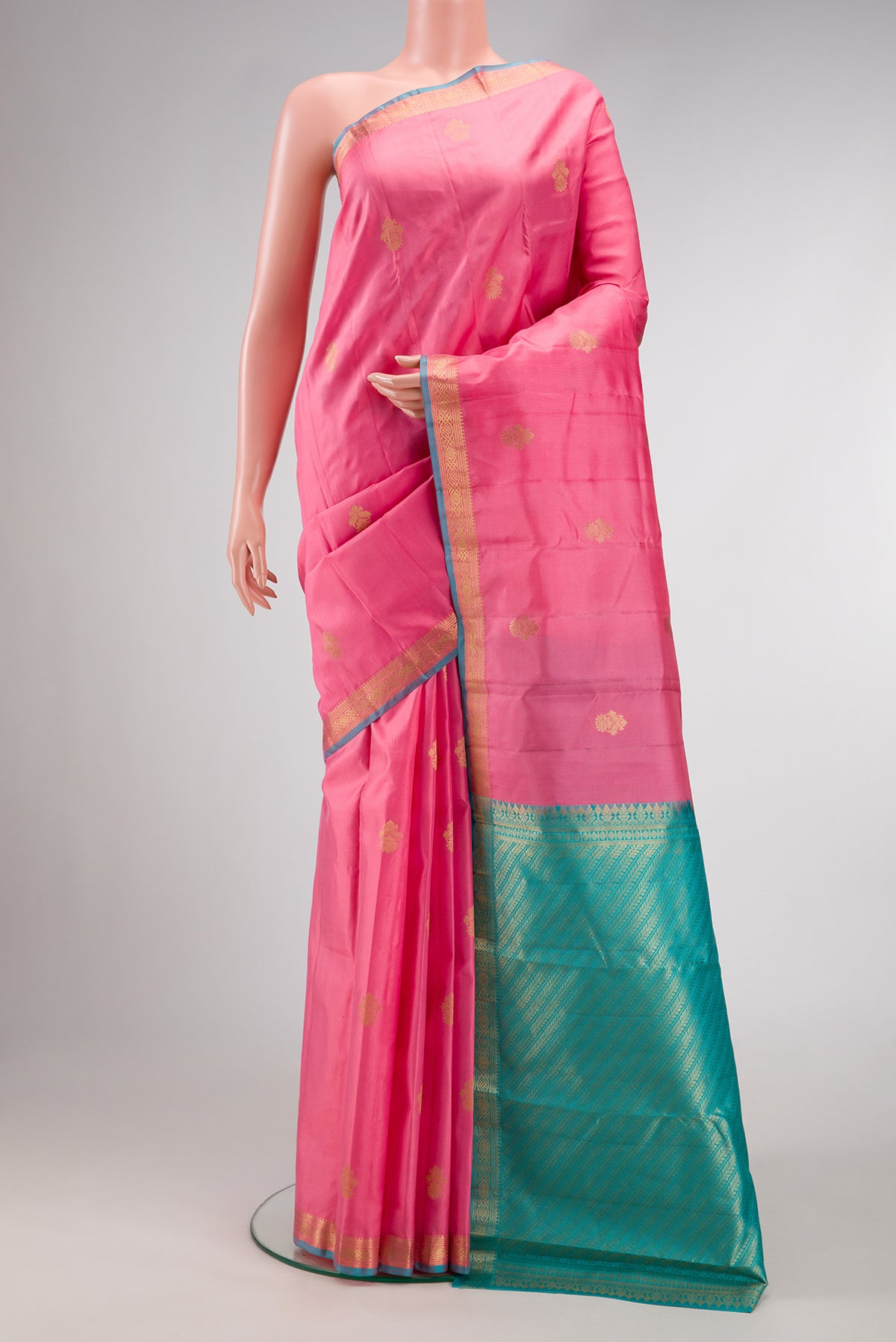 Pink Kanchipuram Silk Saree with Zari Butta on the body and Zari Border.  displayed on a mannequin