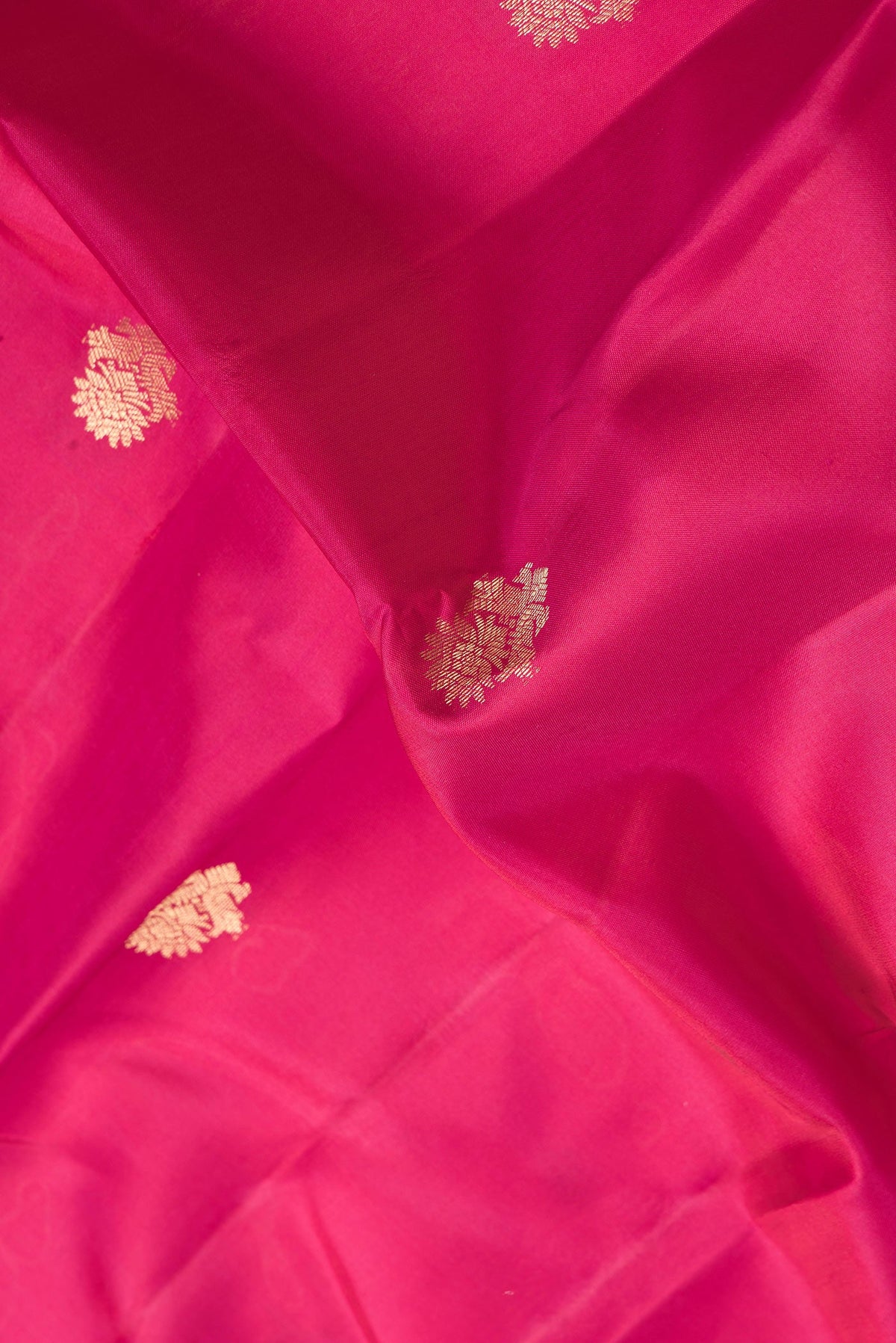 Close up of Pink Dual Tone Kanchipuram Silk Saree with Zari Butta on the body and Zari Border.  displaying folds