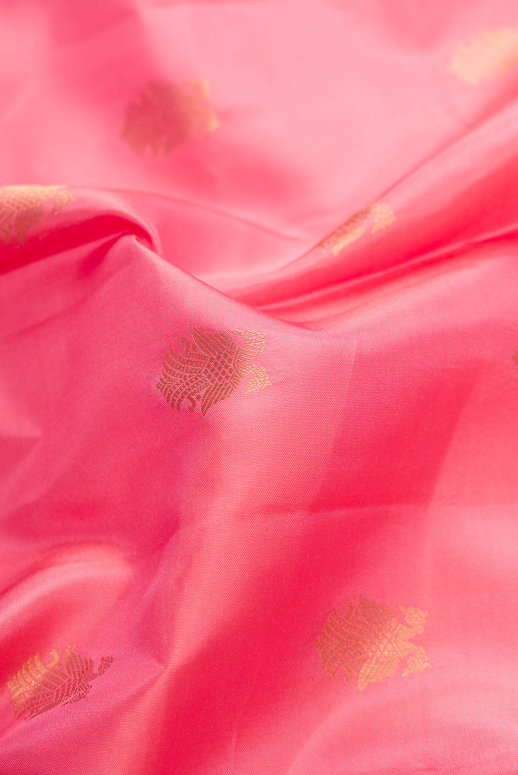 Close up of Pink Kanchipuram Silk Saree with Zari Butta on the body and Zari Border.  displaying folds